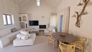 a living room with a couch and a table at Doto Villa with private pool in Agia Effimia
