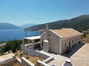 a white house with a view of the water at Doto Villa with private pool in Agia Effimia