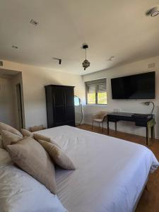 a bedroom with a large white bed with a flat screen tv at Santiurde Suites in Quintanilla de Arriba