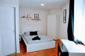a white bedroom with a bed and a window at Dormir près de Brioude - studio 'esprit cocon' in Fontannes