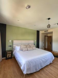 a bedroom with a large white bed in a room at Santiurde Suites in Quintanilla de Arriba