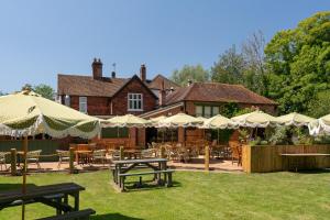 a restaurant with tables and chairs and umbrellas at The Dundas Arms in Kintbury