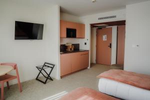 a living room with a couch and a kitchen at Apparté Plus in Brive-la-Gaillarde
