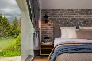 a bedroom with a bed and a brick wall at Flatbook Stegna Południowa Apartamenty z Basenem in Stegna