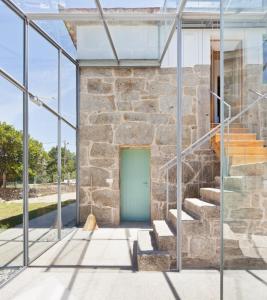 a stone building with a green door and stairs at Casa Caseiros, Couso in Gondomar