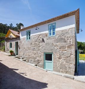 a stone house with a green door on a building at Casa Caseiros, Couso in Gondomar