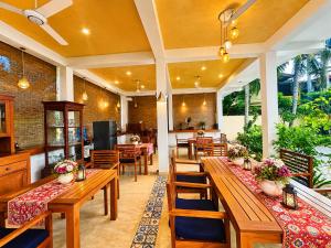 a dining room with wooden tables and chairs at Sky and Sand Guesthouse in Beruwala
