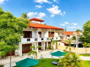 an image of a house with umbrellas in the yard at Sky and Sand Guesthouse in Beruwala
