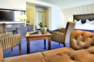 a hotel room with a couch and a bed at Promenadenhotel Admiral in Bansin