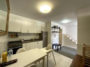a kitchen with white cabinets and a table and chairs at Flat with nice view in Gualtar, Braga in Braga