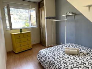 a bedroom with a bed and a dresser and a window at Flat with nice view in Gualtar, Braga in Braga