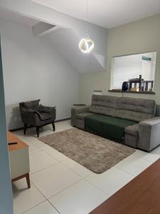 a living room with a couch and a chair at Casa Espaçosa - Caminhe até a Orla de Atalaia 650m in Aracaju