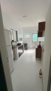 a large white kitchen with a white floor and appliances at Casa Espaçosa - Caminhe até a Orla de Atalaia 650m in Aracaju +22 photos