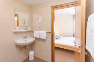 a bathroom with a sink and a toilet and a mirror at Zimmer Katarina in Vodice