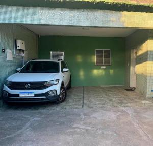 a white car parked inside of a garage at Casa Espaçosa - Caminhe até a Orla de Atalaia 650m in Aracaju