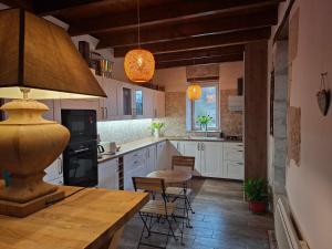 a kitchen with white cabinets and a table and chairs at Casa Oksana in Castelnau-de-Montratier
