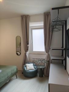 a bedroom with a bed and a chair and a window at The Dome in Orbetello