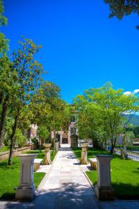 a walkway in a park with trees and grass at Villa dei Papi Subiaco in Subiaco