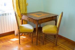 a wooden table with two chairs and a table with at Villa dei Papi Subiaco in Subiaco