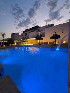 a large swimming pool with blue lighting in front of a building at Hotel Avenida Tropical by Bossh! Hotels in Salobreña