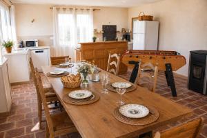 a kitchen with a wooden table and a dining room at Cottage de charme avec piscine et vue panoramique - 6-8 pers Pays d'Auge in Vimoutiers