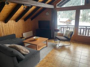 a living room with a couch and a table at L'Attique du Vieux-Champex in Orsières