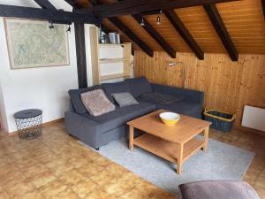 a living room with a blue couch and a table at L'Attique du Vieux-Champex in Orsières +10 photos