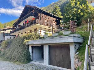a house on the side of a hill with a garage at L'Attique du Vieux-Champex in Orsières