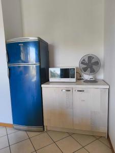 a blue refrigerator and a microwave on a counter at Apartment with three double bedrooms in Altavilla Vicentina +8 photos