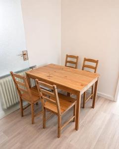 a wooden table with four chairs and a wooden table and chairsktop at Arkadia Monteur-Haus Seevetal in Seevetal