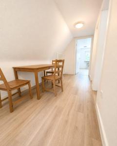 a dining room with a wooden table and chairs at Arkadia Monteur-Haus Seevetal in Seevetal +5 photos