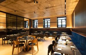 a restaurant with tables and chairs in a room at Breda Suites Hotel Milano in Milan