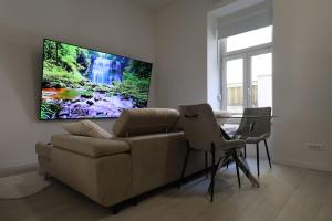 a living room with a couch and a tv on a wall at Downtown Condo w Huge TV in Zagreb