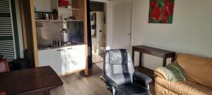 a living room with a couch and a chair at B&B Even Heukelom - Kamer met Tuin in Afferden