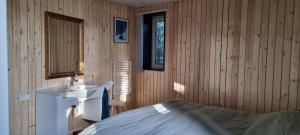 a bedroom with a bed and a sink and a mirror at B&B Even Heukelom - Kamer met Tuin in Afferden