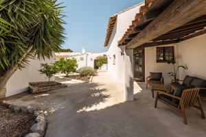 a courtyard of a house with chairs and trees at L'Oustau des Palunettes Concept Adulte only in Saintes-Maries-de-la-Mer