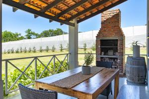 a patio with a table and a brick fireplace at Mon Rêve Estate in Cape Town