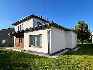 a small white house with a grass yard at Villa Eha in Kuressaare