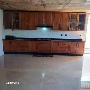 a large kitchen with wooden cabinets and a tile floor at Ponto de Ouro in Lopes +12 photos