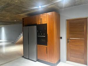 a kitchen with a stainless steel refrigerator and wooden cabinets at Ponto de Ouro in Lopes