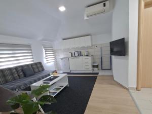 a living room with a couch and a kitchen at Apartments Platz in Mostar