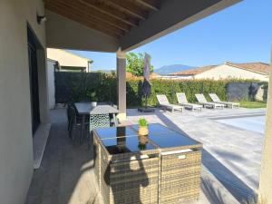 a patio with a table and chairs and a table at villa récente climatisée avec piscine privée in Vaison-la-Romaine