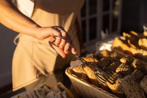 a person holding a pair of tongs over food at Hotel El Patio in Garachico