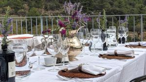 a white table with wine glasses and flowers on it at Hotel Mas de la Serra in Fuentespalda +41 photos
