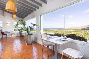 a dining room with a table and chairs and a large window at Hotel El Patio in Garachico