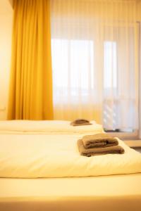 two beds in a hotel room with towels on them at Kotlina smart hotel in Rožňava
