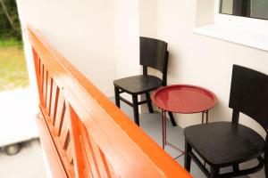 three black and red chairs sitting on a balcony at Kotlina smart hotel in Rožňava
