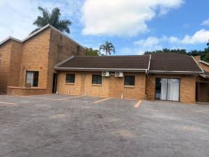 a brick building with a parking lot in front of it at Happy Holiday Lodge in Meer en See