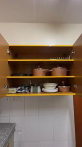 a kitchen with bowls and plates on a shelf at Affar homes in Kumasi