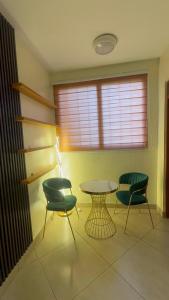 a room with two chairs and a table and a window at Affar homes in Kumasi